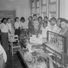 Classroom. Men and women gathered around classroom lab tables with equipment, ca. 1947. Paul Henderson, HEN.00.B2-248.
