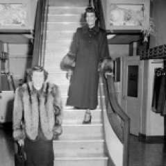 Two unidentified women in coats inside clothing store, circa 1949. Paul Henderson, HEN.00.B1-103.