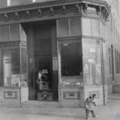 Exterior view of Phillip's Groceries. Shows child standing on sidewalk, undated. Paul Henderson, HEN.00.B1-131.